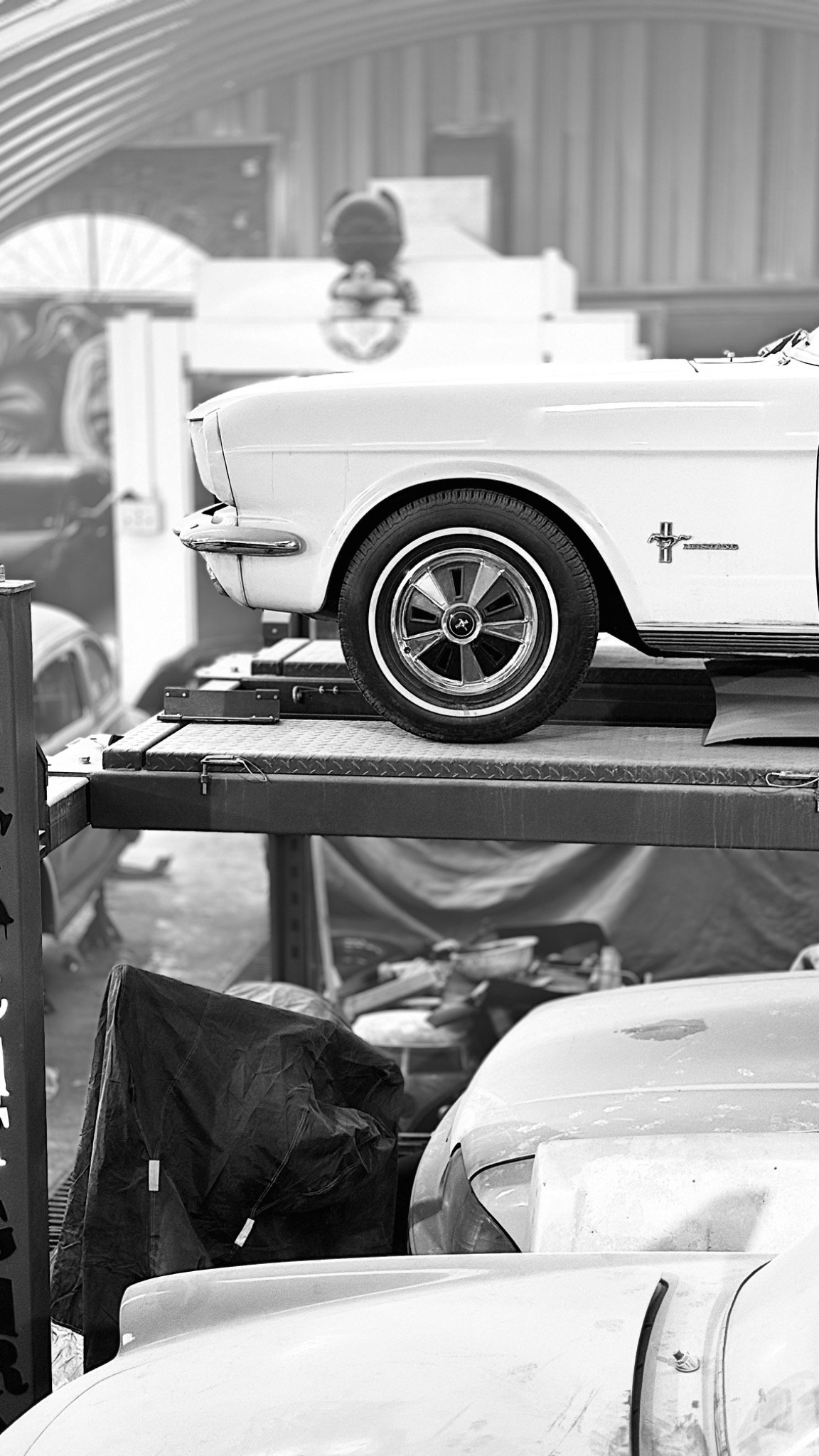 Vehículos clásicos dentro del taller en fotografía en blanco y negro