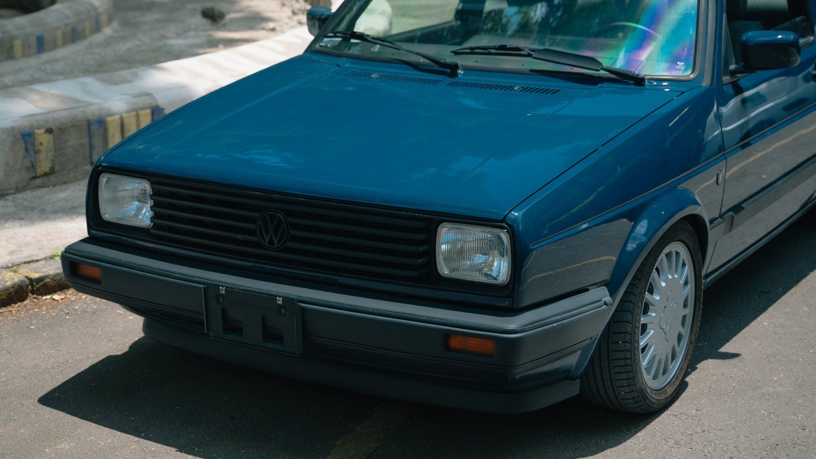 Volkswagen azul visto de frente y costado