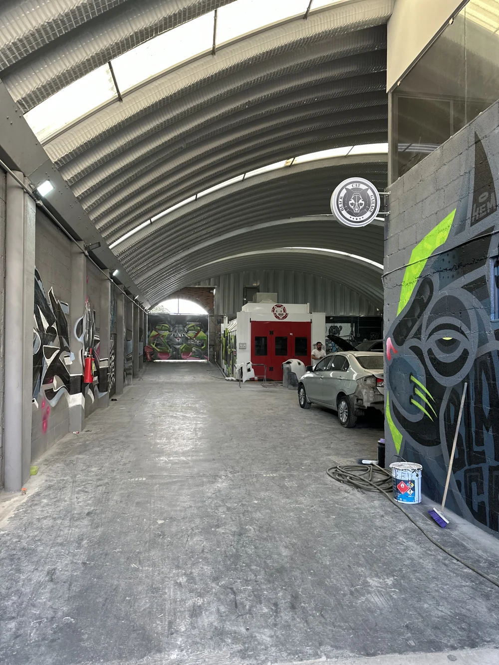Interior del taller Black Cat Garage con murales y área de trabajo